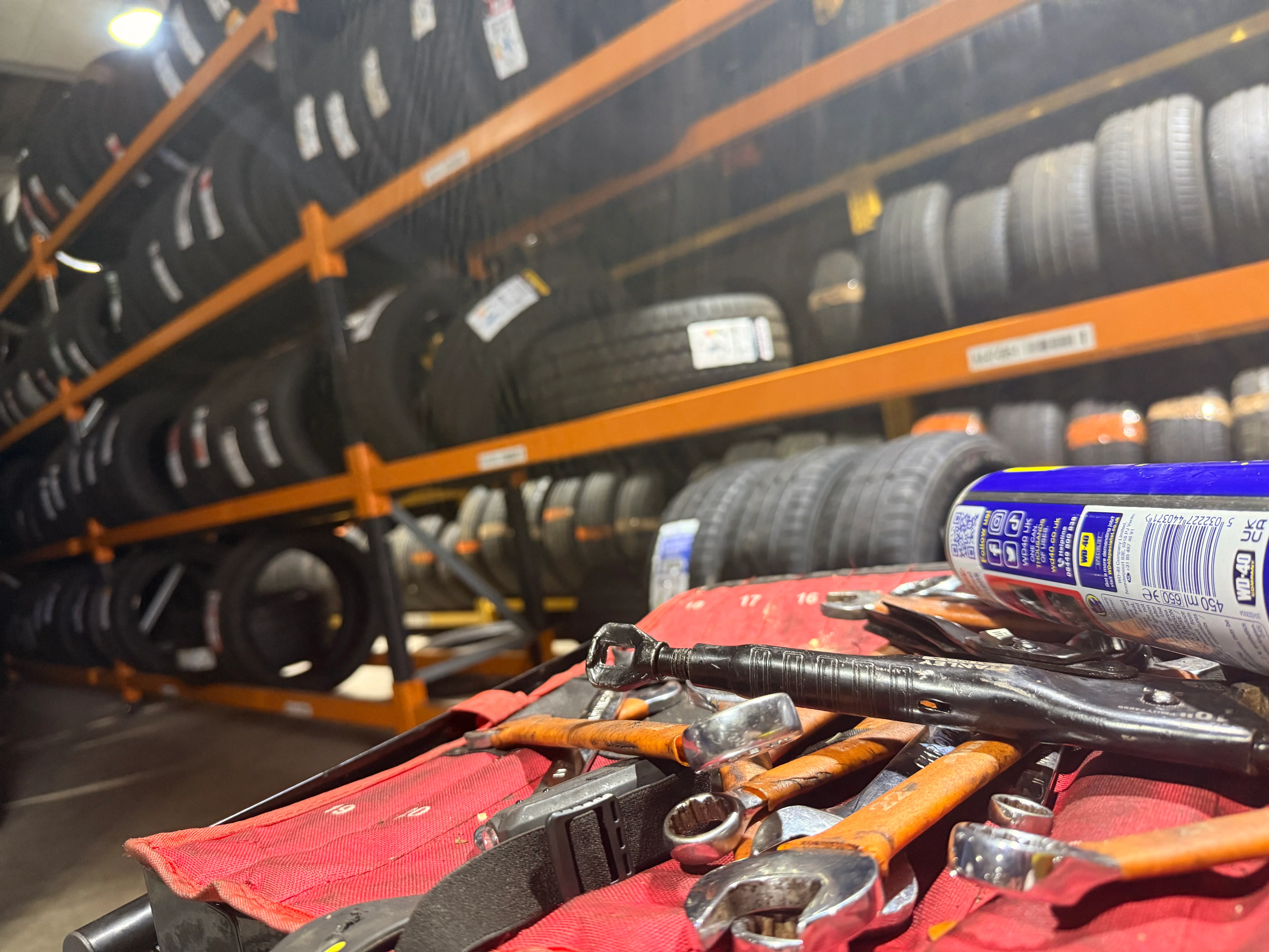 A ford pikcup on a ramp inside a garage.