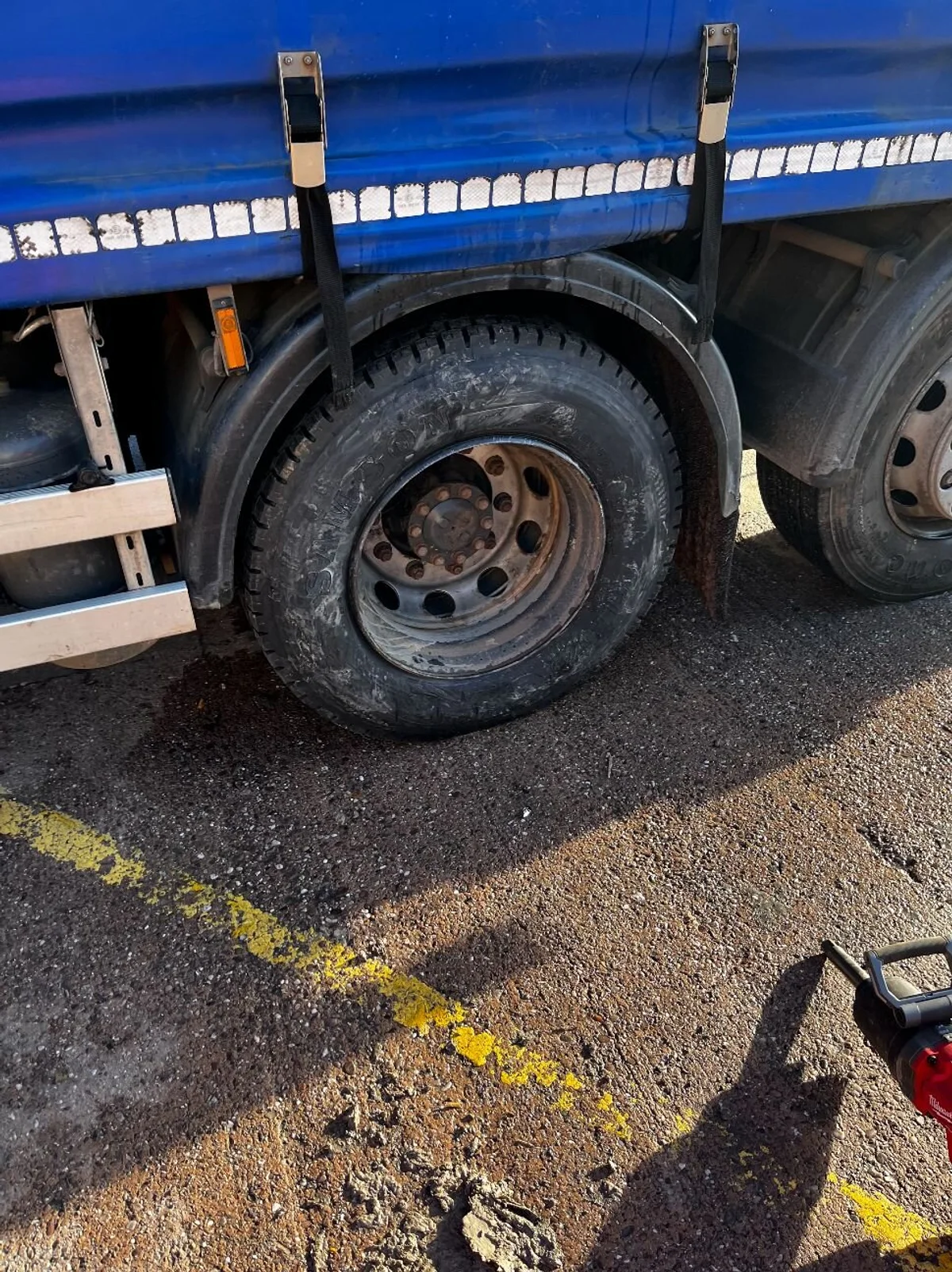 Truck tyre being replaced on a blue truck
